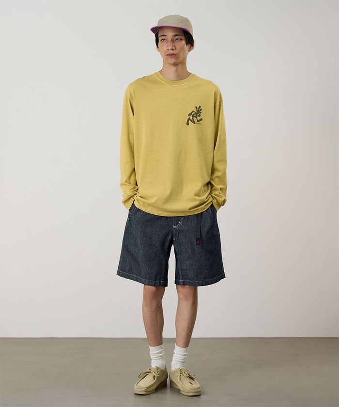 Model wearing navy Gramicci Japanese Chambray Shorts and a yellow shirt on a light-tone background.