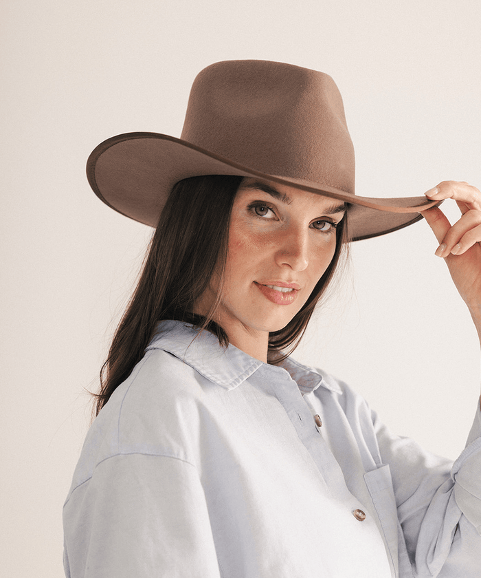 Woman wearing a brown felt hat on a white background #color_brown