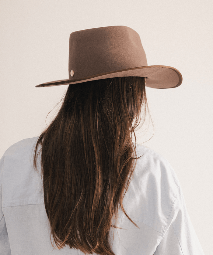 Woman wearing a brown felt hat on a white background #color_brown