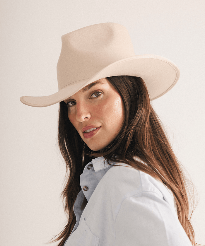 Woman wearing a beige felt hat on a white background #color_cream