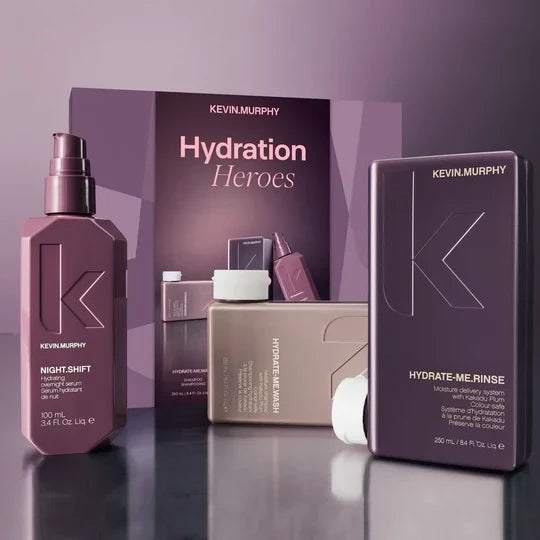 Kevin Murphy Haircare 'Hydration Heroes' gift set featuring a Night-Shift hair serum bottle, a Hydrate-Me Rinse box, and a Hydrate-Me Serum box, arranged in front of a branded display card on a reflective dark surface.