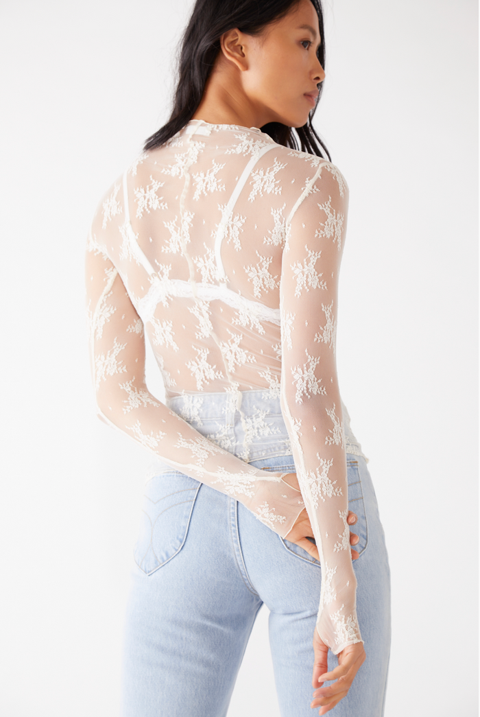 Woman wearing light colored jeans and Free People Lady Lux Layering Top in Creme