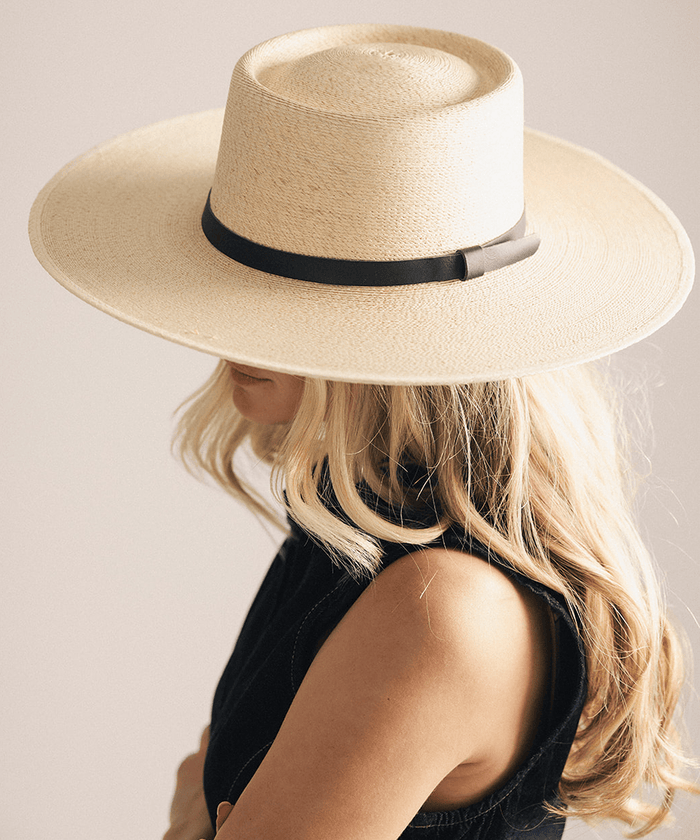 Woman wearing a beige straw hat against a white background #color_natural