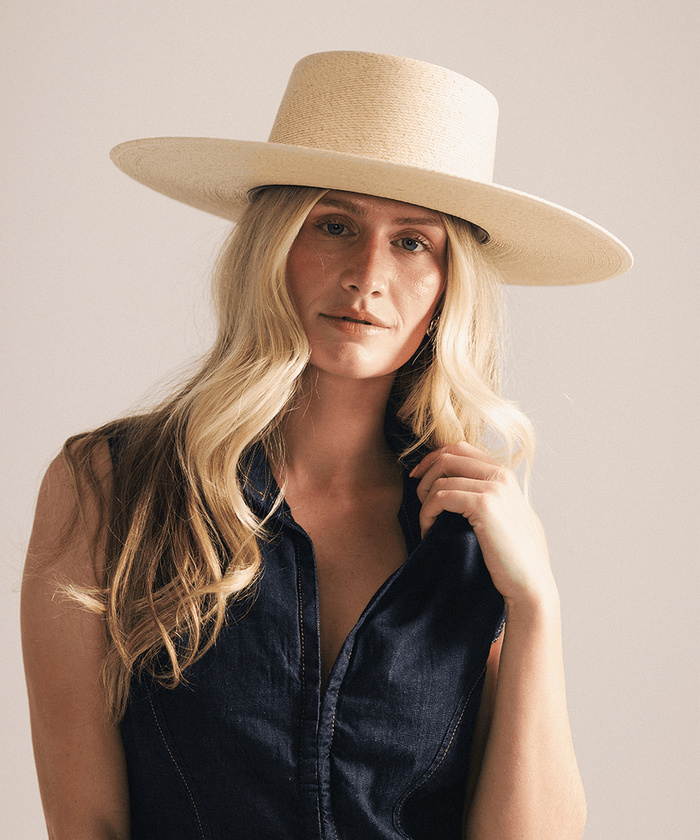Woman wearing a beige straw hat against a white background #color_natural