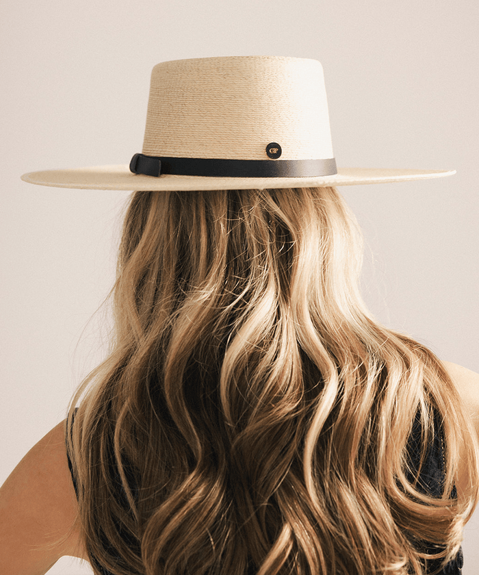 Woman wearing a beige straw hat against a white background #color_natural