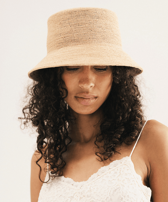 Woman wearing a beige bucket hat against a white background #color_natural
