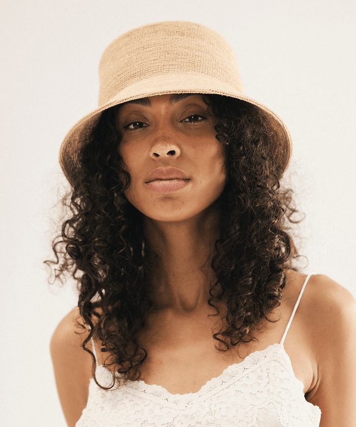 Woman wearing a beige bucket hat against a white background #color_natural