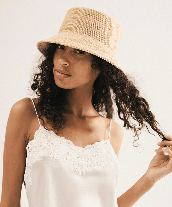 Woman wearing a beige bucket hat against a white background #color_natural