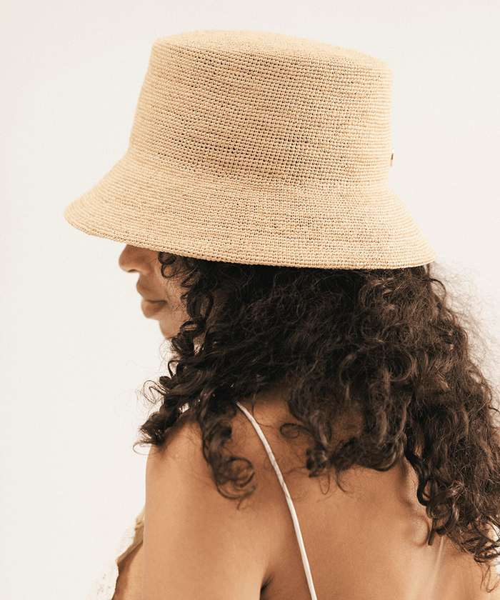 Woman wearing a beige bucket hat against a white background #color_natural