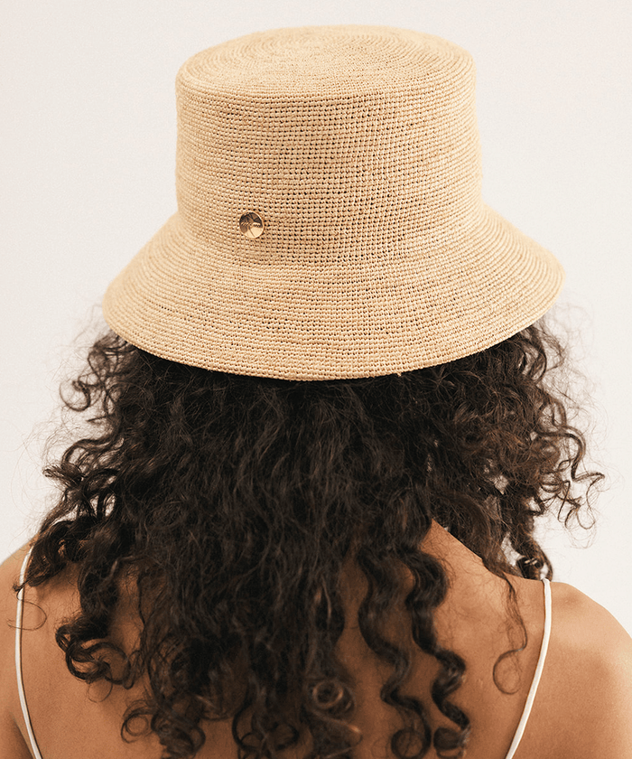 Woman wearing a beige bucket hat against a white background #color_natural