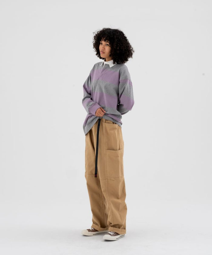 Model wearing beige Gramicci Voyager Pants and a lavender and grey stripped Gramicci Langdon Rugby  Long-Sleeve shirt on a light-tone background.