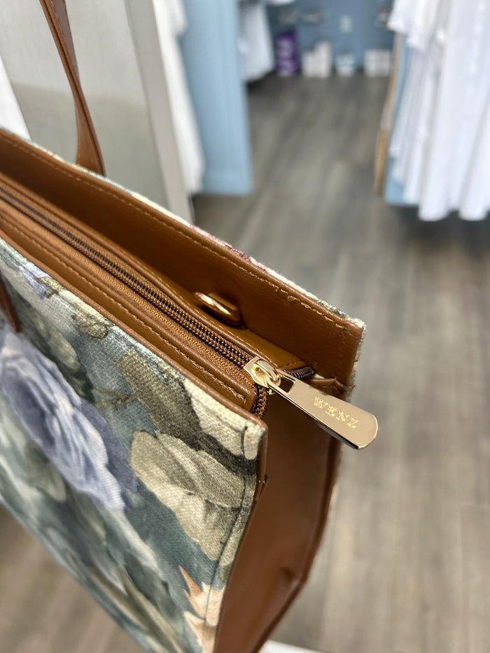 Tote bag with zipper and handle attachments.