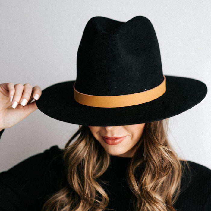 Woman wearing a black hat with a camel colored leather adjustable chain band against a plain background #color_camel