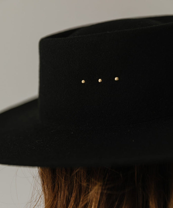 A black boater hat with three gold plated studs on the crown  #color_black