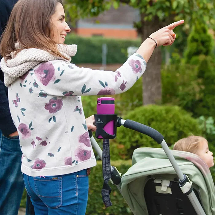 A pushchair with a Littlelife buggy cup holder attached to its handle whilst holding a thermal mug