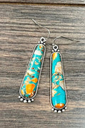 Southwestern turquoise and spiny oyster drop earrings featuring elongated stone inlays framed in antique silver. Western-inspired statement earrings perfect for rodeos, country concerts, cowgirl outfits, and everyday boutique styling.