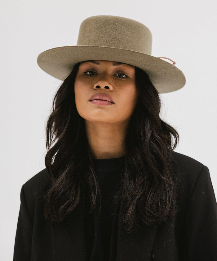Woman wearing an aloe colored Maise classic flat brim hat and a black blazer against a plain background #color_aloe