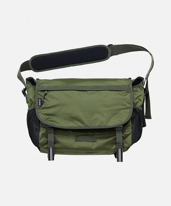 Olive and black Gramicci Messenger Bag on a light tone background.