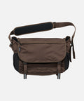 Brown and black Gramicci Messenger Bag on a light tone background.