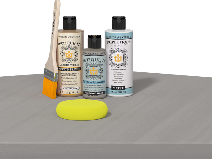 Retique It® Weathered Wood Multipurpose Kit contents with Light Wood Liquid Wood primer, Weathered Wood gel stain alternative, Tripletique matte interior top coat, paintbrush, and yellow sponge displayed on a wood surface.