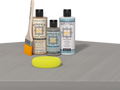 Retique It® Weathered Wood Multipurpose Kit contents with Light Wood Liquid Wood primer, Weathered Wood gel stain alternative, Tripletique matte interior top coat, paintbrush, and yellow sponge displayed on a wood surface.