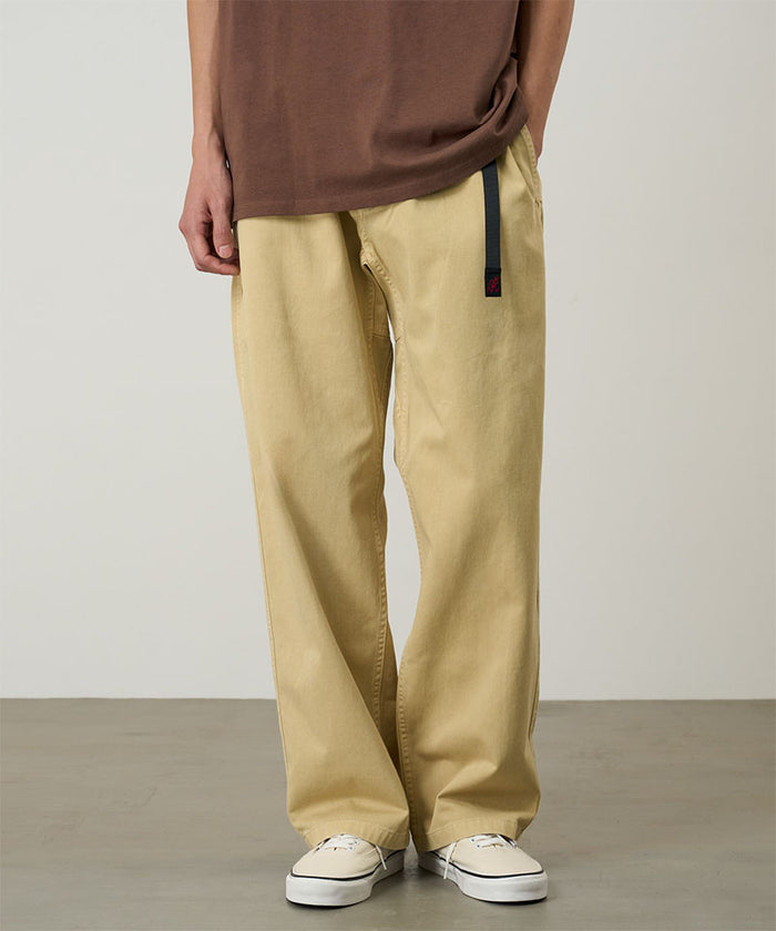 Model wearing a Natural Dyed Gramicci Pant Straight Fit in the color chino on a light-tone background.