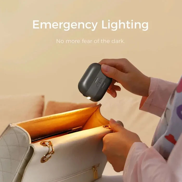 A woman using a Ocoopa Heat Cube rechargeable hand warmer in black to search in her handbag using the integrated light