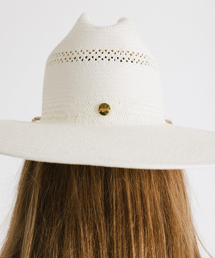 Person wearing a cream straw hat against a plain background #color_cream