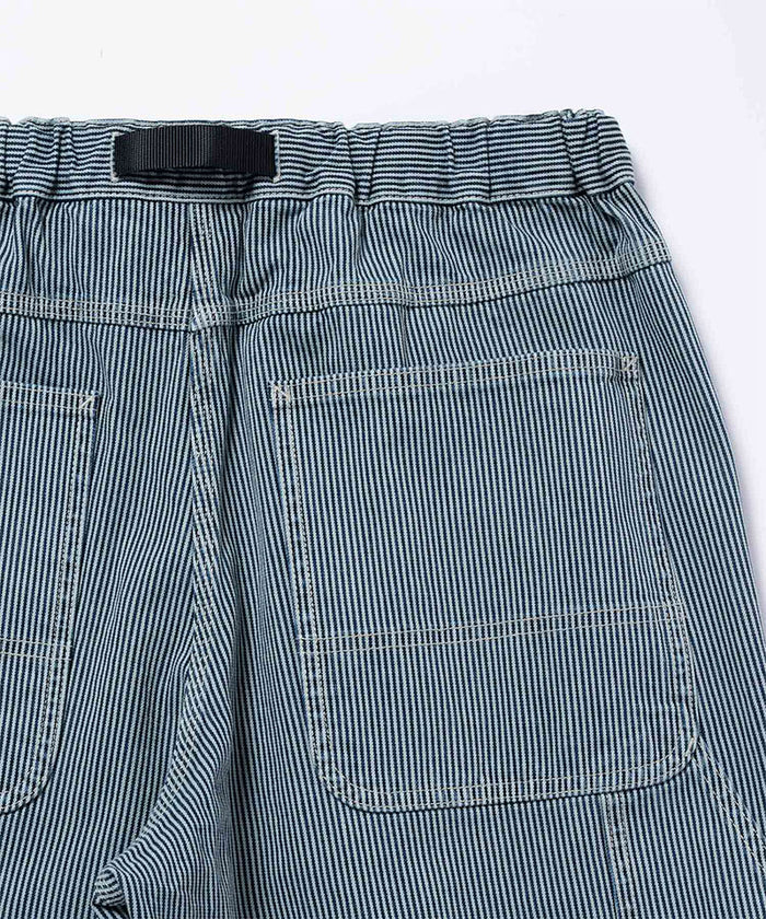 Back view close-up of navy Gramicci Overdyed Hickory Work Pants on a light-tone background.