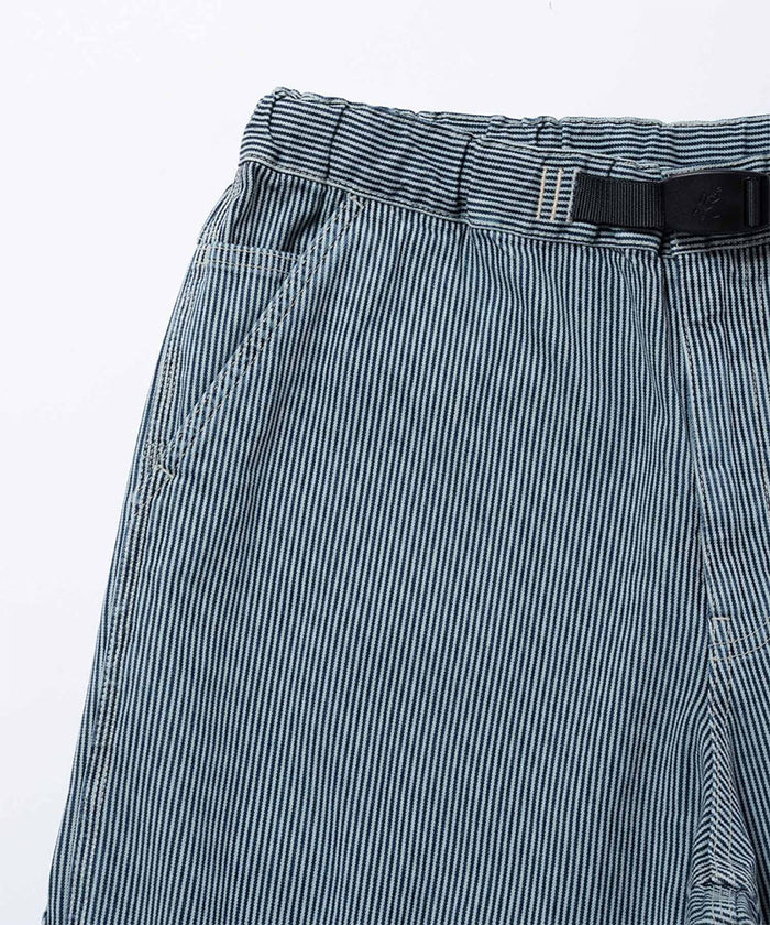 Close-up view of navy Gramicci Overdyed Hickory Work Pants on a light-tone background.