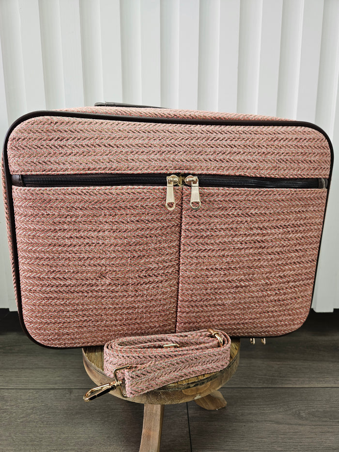 Pink suitcase bag with shoulder strap.
