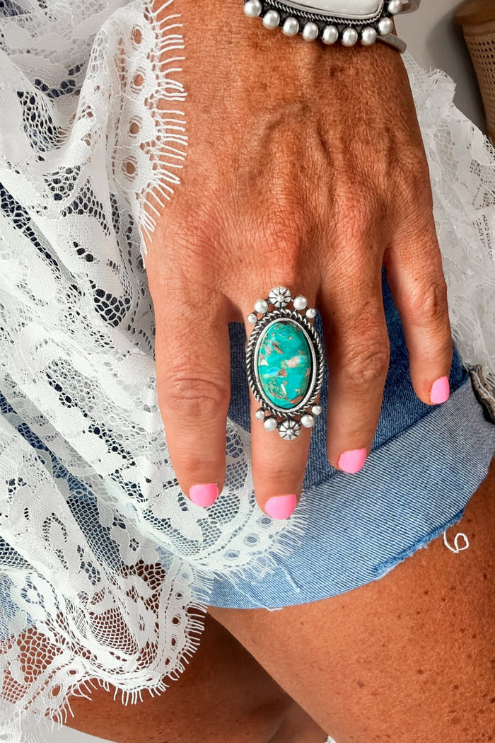 Southwestern turquoise statement ring with a large oval turquoise matrix stone and antique silver detailing, perfect for western outfits, rodeos, and country concert fashion.