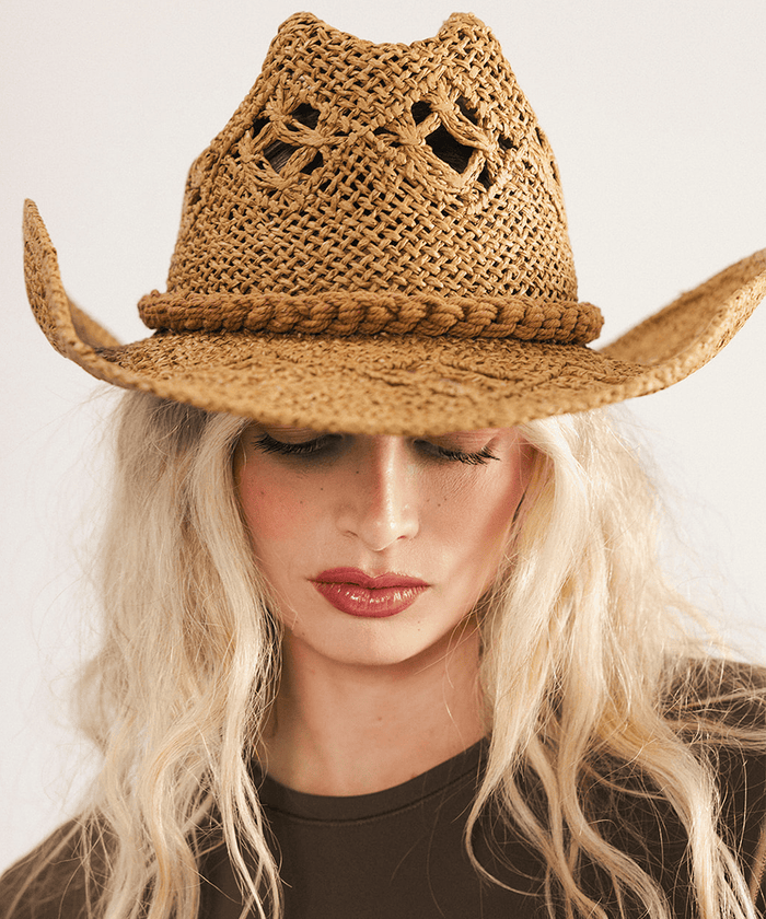 Woman wearing a honey colored paper rope straw cowboy hat with a classic cattleman crown and a wide brim featuring large venting details for airflow against a plain background #color_honey