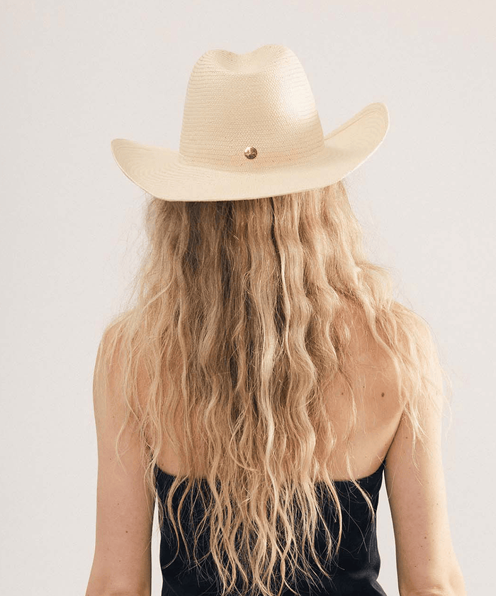 Woman wearing a natural colored straw cowboy hat with a fedora crown and a rolled western brim, displayed on a white background. #color_natural