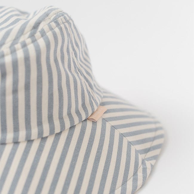 Close up image of a blue and white striped bucket hat on a plain background #color_striped - blue