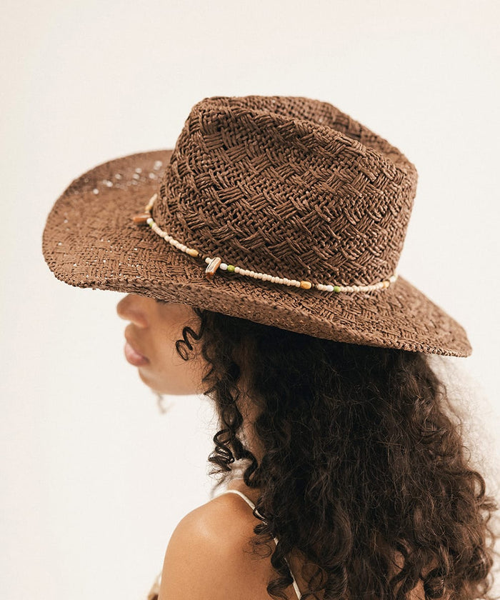 Woman wearing a brown straw hat with a white background #color_chocolate