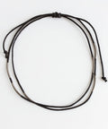A black rope band with beads on a white background #color_black