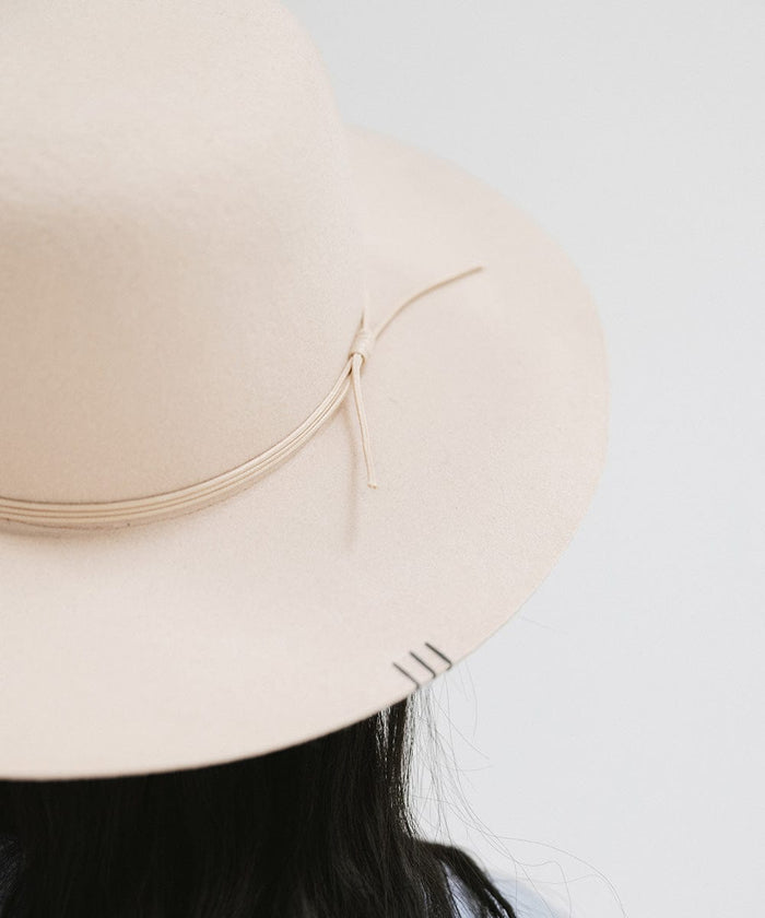 A cream open crown hat with a hat band against a plain background #color_cream