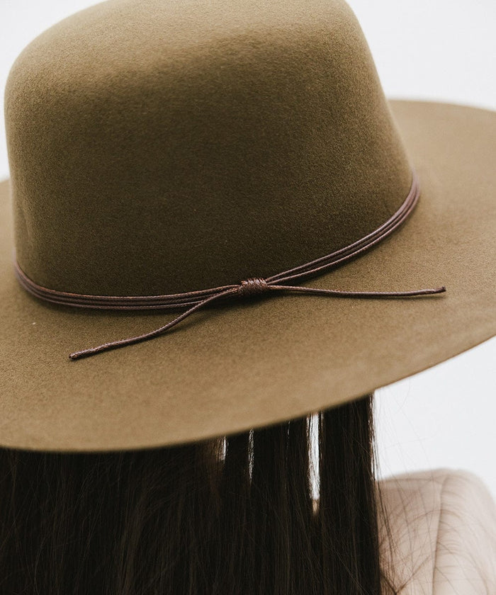 An olive colored open crown hat with a hat band against a plain background #color_olive