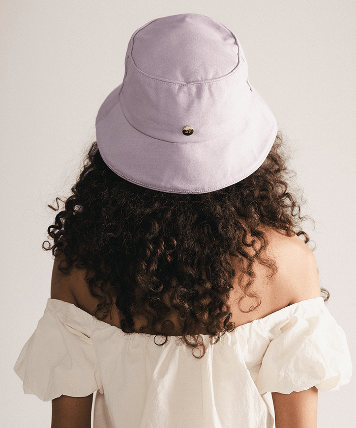 Woman wearing a lavender bucket hat with a plain background #color_lavender