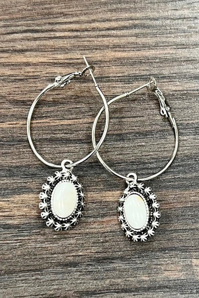 Saddle Stories hoop earrings featuring white turquoise oval stones, antique silver western detailing, and classic hoop styling for western-inspired outfits and everyday wear.