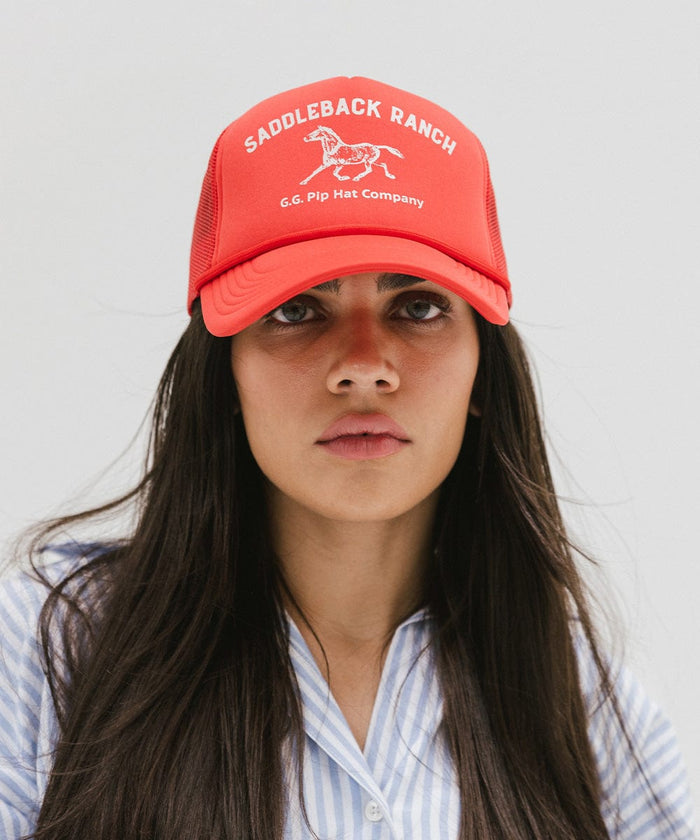 Woman wearing a vintage red colored cap with 'Saddleback Ranch' text and logo, and a light colored shirt against a plain background  #color_vintage red