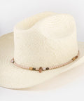 Beige straw hat with a decorative band on a plain background #color_natural