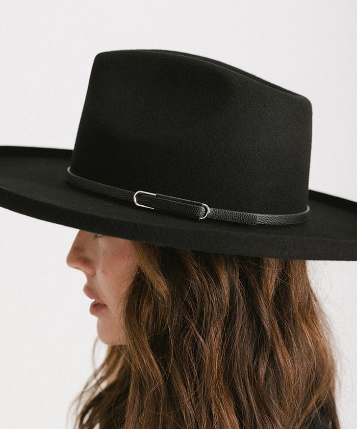 Woman wearing a black wide-brimmed hat with a black hat band, facing sideways against a plain background #color_black - silver