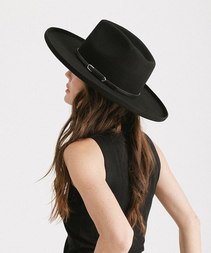 Woman wearing a black wide-brimmed hat with a black hat band and a black top, facing sideways against a plain background #color_black - silver