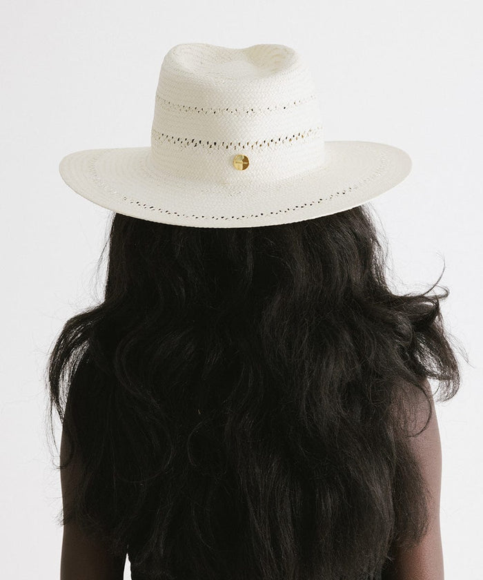 Woman wearing a white straw fedora hat with decorative trim facing behind against a plain background  #color_white