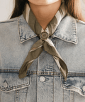 Person wearing a denim jacket with a green scarf tied with a Sunburst Concho Bandana Slide around the neck #color_gold