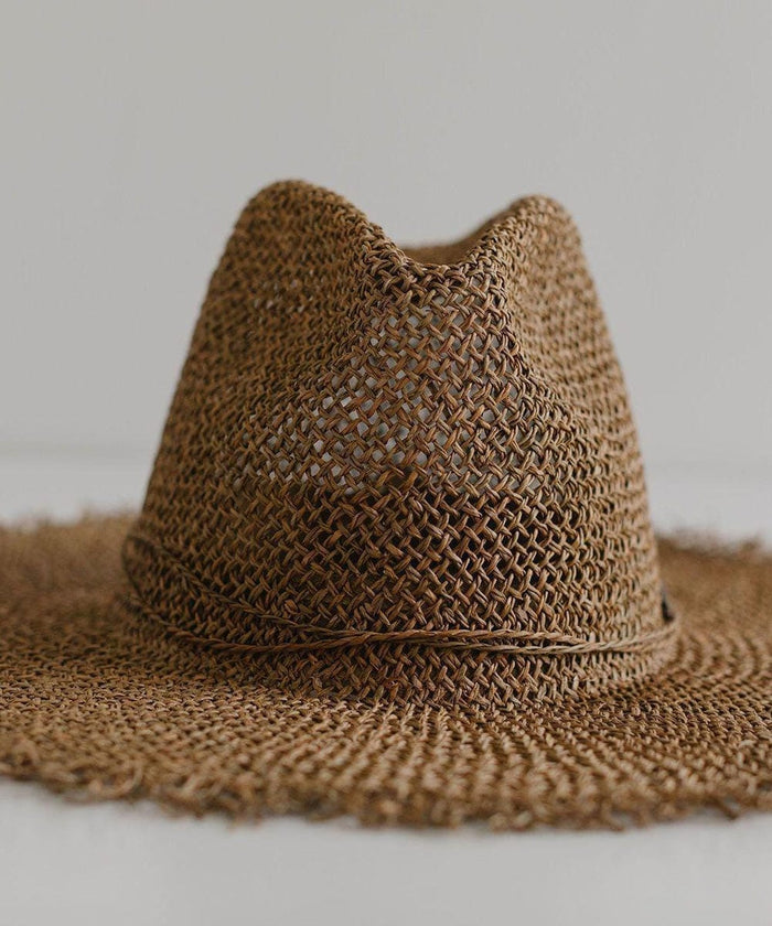Close up image of a brown straw fedora hat with a band on a plain background #color_brown