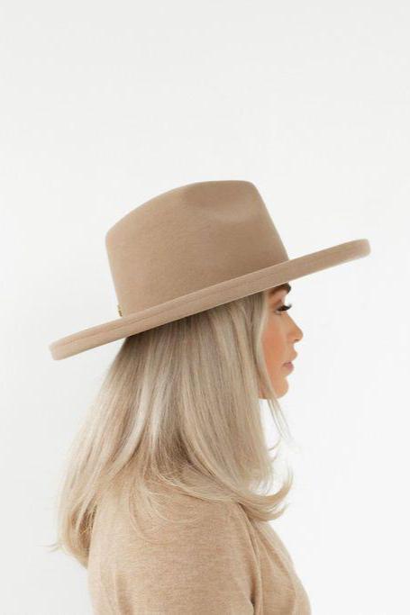 Woman wearing a tan pencil brim felt hat and a beige shirt, facing sideways against a plain background #color_tan