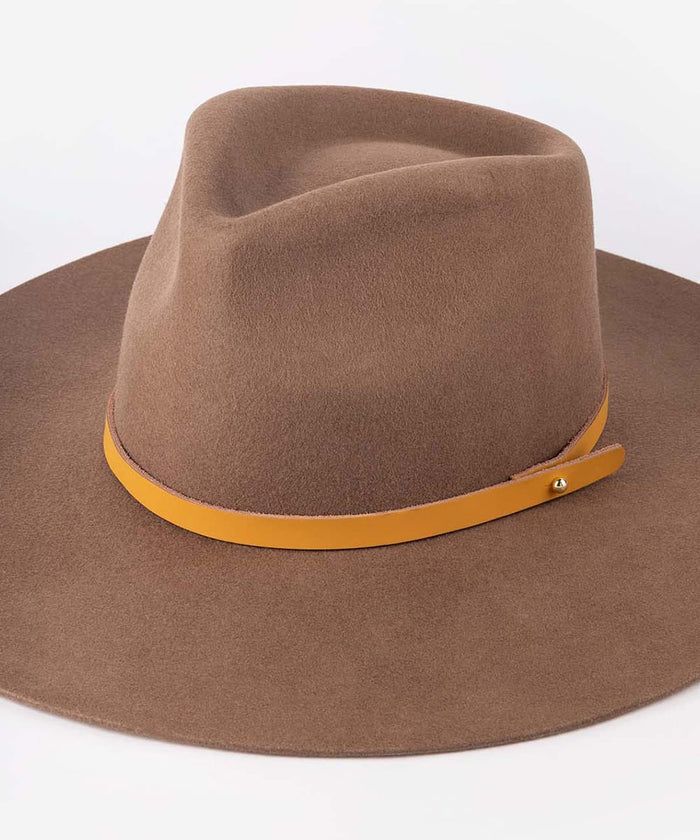 A brown felt wide-brim hat with a contrasting mustard yellow leather band and a small gold-tone metal stud, shown on a plain white background #color_cognac